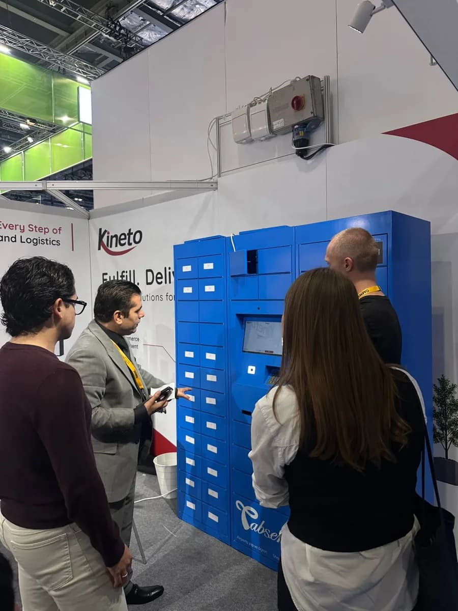 Visitors trying the smart locker touchscreen at the Kineto booth, Parcel+Post Expo London 2026