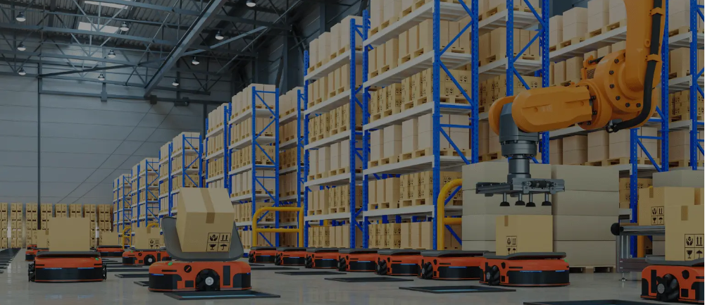 kineto A warehouse with tall blue shelves filled with boxes, robotic arms moving packages, and several automated robots transporting boxes on the floor. The setting is clean and well-lit, showcasing advanced warehouse automation.